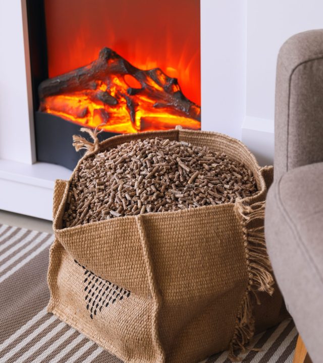 Bag,With,Wood,Pellets,Near,Fireplace,In,Living,Room