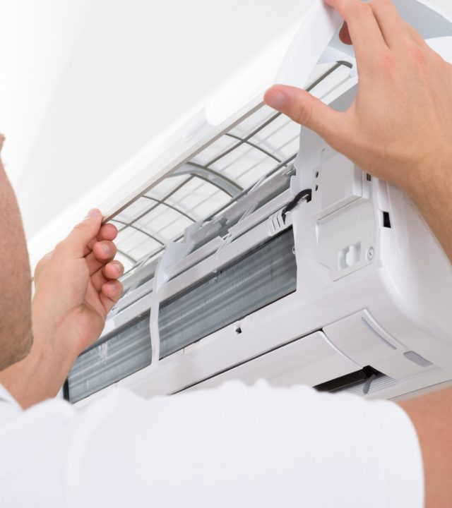 Portrait,Of,A,Young,Man,Adjusting,Air,Conditioning,System